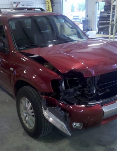 A red SUV with a badly damaged front end