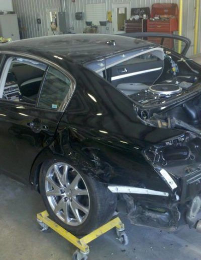 A black car undergoing repair on the back end