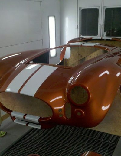 A classic car body with a fresh coat of orange paint