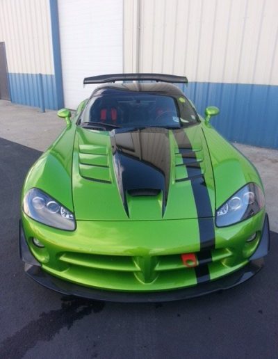 A custom painted green car with black stripe